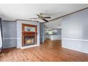 Living room featuring a classic fireplace and wood-look floors that flow into the kitchen at 4047 Mistletoe Dr, Burlington, NC 27217