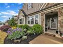 Lush landscaping surrounds the home's entry, showcasing vibrant flowers, plants, and stone accents at 412 Airedale Trl, Garner, NC 27529