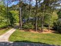Spacious lot with mature trees surrounding a beautiful home and long private driveway at 4533 Wood Valley Dr, Raleigh, NC 27613