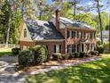 Brick home with a well-maintained lawn, mature trees, and a side-entry garage at 4533 Wood Valley Dr, Raleigh, NC 27613