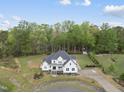 Aerial view of a stunning two-story home, lush landscaping, and a long private driveway at 6024 Lunenburg Dr, Raleigh, NC 27603