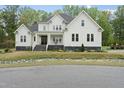 Inviting two-story home with a classic white facade, stone foundation, and well-manicured lawn at 6024 Lunenburg Dr, Raleigh, NC 27603