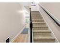 Carpeted staircase with a sleek black handrail leading to the upper level of this beautiful home at 705 Samuel Cary Dr, Cary, NC 27511