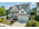 Charming home featuring stone accents, a well-kept lawn, and an attached two-car garage at 7101 Gibson Creek Pl, Cary, NC 27519