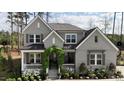 Charming gray two-story home with a lush green lawn and inviting front porch and walkway at 8208 Bella Oak Ct, Wake Forest, NC 27587
