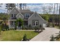 Charming home featuring a welcoming front porch with vine archway, lush lawn, and lovely landscaping at 8208 Bella Oak Ct, Wake Forest, NC 27587