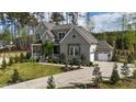 Charming gray two-story home with a lush green lawn and inviting front porch and walkway at 8208 Bella Oak Ct, Wake Forest, NC 27587