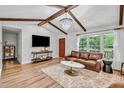 Well-lit living room showcasing hardwood floors, exposed beams, and stylish furnishings at 905 Tyler Ct, Garner, NC 27529