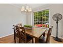 Bright dining room featuring hardwood floors and a large window overlooking the landscaped front yard at 918 Albany Ct, Raleigh, NC 27615