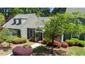 Inviting gray home featuring a picturesque front yard with a manicured lawn, colorful bushes, and mature trees at 918 Albany Ct, Raleigh, NC 27615