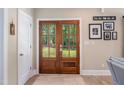 Inviting entryway featuring decorative wood double doors that overlook a beautiful yard and a contrasting white interior door at 9947 Nc Hwy 96 N, Selma, NC 27576