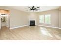 Bright living room featuring a modern fireplace, ceiling fan, and hardwood floors at 1004 Longleaf Pine Pl, Mebane, NC 27302