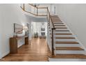Bright foyer with hardwood floors, open staircase, and views into the living room at 103 Ticonderoga Rd, Cary, NC 27519