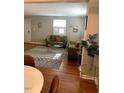 Cozy living room with hardwood floors, stylish rug, and comfortable green sofas at 1045 Nichols Dr, Raleigh, NC 27605