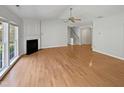 Spacious living room with hardwood floors, fireplace, staircase, and ceiling fan at 107 Kinship Ln, Apex, NC 27502