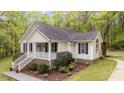 A beautiful home with a cozy front porch and landscaped front yard nestled in a wooded area at 1106 Lake Ridge Dr, Creedmoor, NC 27522