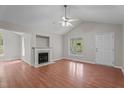 Bright living room featuring a fireplace, ceiling fan, and large window offering a scenic outdoor view at 1106 Lake Ridge Dr, Creedmoor, NC 27522