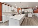 A modern kitchen features white cabinets, stainless steel appliances, and a large island at 1216 Edgemoore Trl, Wake Forest, NC 27587