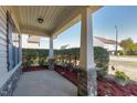Covered porch with stone pillars, providing a welcoming outdoor space with manicured shrubs at 138 Horizon Trl, Garner, NC 27529
