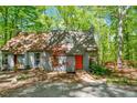 Inviting home exterior featuring a wooden walkway to the orange front door, surrounded by lush greenery and trees at 158 Poplar St # A, Chapel Hill, NC 27516