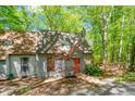Home exterior showcasing a gray facade, orange front door with a wooden walkway, deck, and surrounded by lush landscaping at 158 Poplar St # A, Chapel Hill, NC 27516