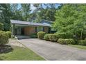 View of a brick home with an attached carport and long concrete driveway at 1636 Cone Ave, Apex, NC 27502