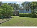 View of a charming home with lush landscaping, mature trees and healthy green lawn at 1636 Cone Ave, Apex, NC 27502
