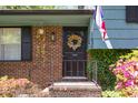Inviting front entrance with brickwork, flowering plants, and a decorative wreath at 1636 Cone Ave, Apex, NC 27502