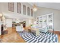 Open-concept living room with hardwood floors, built-in shelving, fireplace, and soaring ceilings at 1715 Us 15-501 S, Chapel Hill, NC 27517