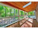 Relaxing covered porch with wooden ceiling, skylight, and views of the surrounding lush greenery at 1715 Us 15-501 S, Chapel Hill, NC 27517