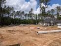 A construction site with new home foundation and pipes surrounded by tall trees at 1737 Pecan Drive # 21, Nashville, NC 27856