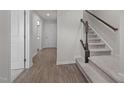 Neutral entryway featuring hardwood floors, carpeted stairs, and a coat closet for storage at 209 Timber Forest Ln, Cary, NC 27519