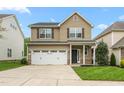 Charming two-story home featuring a two-car garage, neutral siding, well maintained lawn and stone accents on the facade at 2103 Glenkirk Dr, Burlington, NC 27215