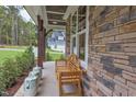 Cozy front porch with stone accents and a wooden bench, perfect for relaxing outdoors at 2113 Mt Sinai Rd, Chapel Hill, NC 27514