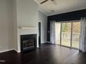 Open living room featuring a fireplace, hardwood floors, and a sliding glass door to the outside patio at 2124 Claret Ln, Morrisville, NC 27560
