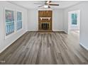 Bright and spacious living room with vinyl plank flooring, a brick fireplace and big windows at 213 Dwelling Pl, Knightdale, NC 27545