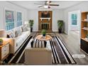 Bright living room featuring a brick fireplace, modern furnishings, and large windows at 213 Dwelling Pl, Knightdale, NC 27545