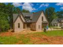 An attractive home features brickwork and a unique roof, complemented by lush green surroundings at 2305 Ballywater Lea Way, Wake Forest, NC 27587