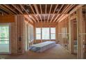 Unfinished room featuring studs, open ceiling, and multiple windows for natural light at 2305 Ballywater Lea Way, Wake Forest, NC 27587
