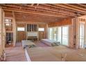 Spacious room with wall studs, open ceiling, fireplace, and sliding glass doors at 2305 Ballywater Lea Way, Wake Forest, NC 27587