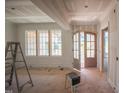 Unfinished living room with large windows, detailed wall paneling, and an arched doorway at 2305 Ballywater Lea Way, Wake Forest, NC 27587