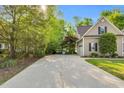 Long driveway leading to a two-car garage, surrounded by mature trees and lush greenery at 262 Windgate Dr, Clayton, NC 27527