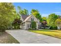 Traditional home boasting a well-manicured lawn, mature trees, and a long driveway leading to a two-car garage at 262 Windgate Dr, Clayton, NC 27527