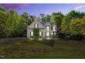 Charming home featuring lush landscaping and a well-maintained lawn, illuminated by landscape lighting at 262 Windgate Dr, Clayton, NC 27527