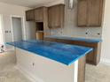 New kitchen featuring an island, wood cabinets, and gray backsplash, ready for customization at 3022 White Rail Dr, Fuquay Varina, NC 27526