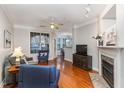 Bright living room with hardwood floors, fireplace, ceiling fan, and view of dining area at 311 Providence Glen Dr, Chapel Hill, NC 27514