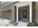 Inviting front entrance featuring a decorative black front door, brick facade, and two-car garage at 317 Castle Rock Ln, Cary, NC 27519