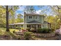 Beautiful home featuring a sunroom with large windows and professionally landscaped yard with flower beds at 373 Sagamore Dr, Louisburg, NC 27549