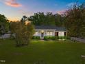 Beautiful single-story home featuring a lush green lawn and mature trees at 410 Long Ave, Roxboro, NC 27573