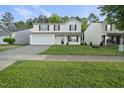 Inviting two-story home featuring a well-manicured front lawn and attached garage at 413 Weeping Willow Dr, Durham, NC 27704